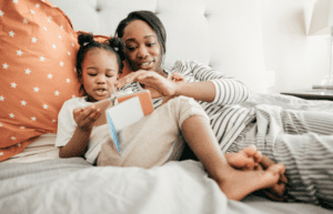Child and mother look at book in bed