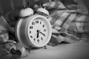 Round alarm clock beside bed