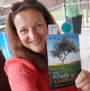 Smiling woman holding book: The Power of Awareness